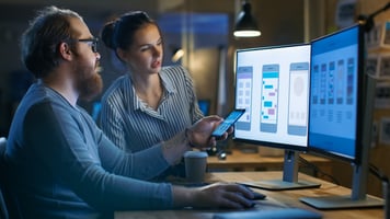 Man and woman reviewing user interface screens