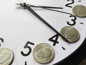 Concept of time is money dollar coins on analog clock
