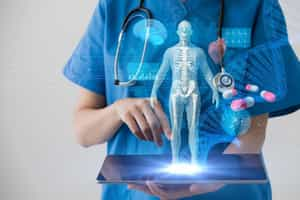 Medical worker in scrubs holding laptop computer